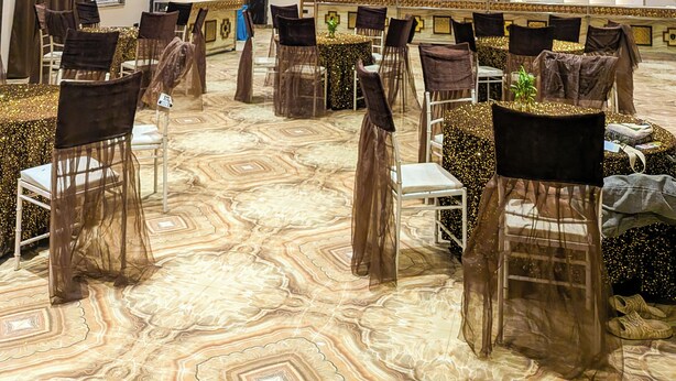 A conference room with a marble-patterned floor, rows of chairs, and a modern ceiling design.
