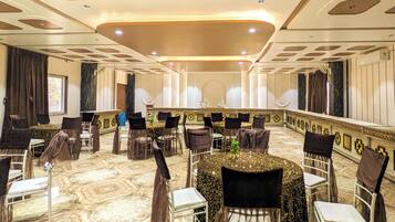 A banquet hall with round tables, chairs, and a marble floor.