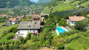 Zona residencial con casas, piscina y abundante vegetación.
