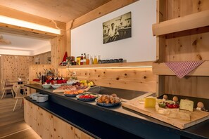 Ein Holzinterieur mit einer Speiseauslage, auf der verschiedene Speisen präsentiert werden, und einem an der Wand hängenden Bild.