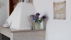 Un taulell de cuina amb un cartell de cafè, un ram de flors i un bocal d'espècies.