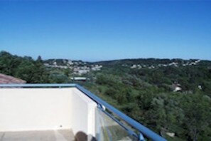 Eine Dachterrasse mit freiem Blick auf eine hügelige Landschaft.