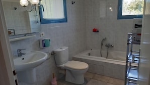 Ein Badezimmer mit Waschbecken, Toilette, Badewanne und Spiegel.