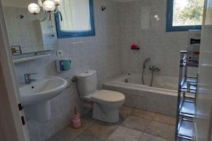 Ein Badezimmer mit Waschbecken, Toilette, Badewanne und Spiegel.