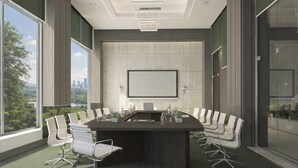 Ein Konferenzraum mit großem Tisch, Stühlen, einer Projektionsleinwand und Blick auf eine Skyline durch große Fenster.