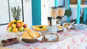 A breakfast buffet with fruits, bread, and cereal. - July10th Hotel By Punta Rucia (Punta Rucia)