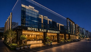 Un moderno edificio de hotel con fachada de vidrio, una zona de recepción y una entrada bien iluminada.