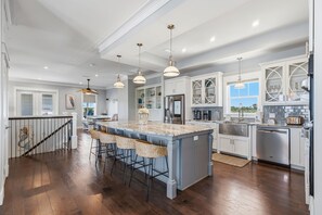 A spacious kitchen with a large island, pendant lighting, and white cabinetry. - Serenade by the Sea! Coastal Escape, Private Pool, Gulf Views (Panama City Beach)