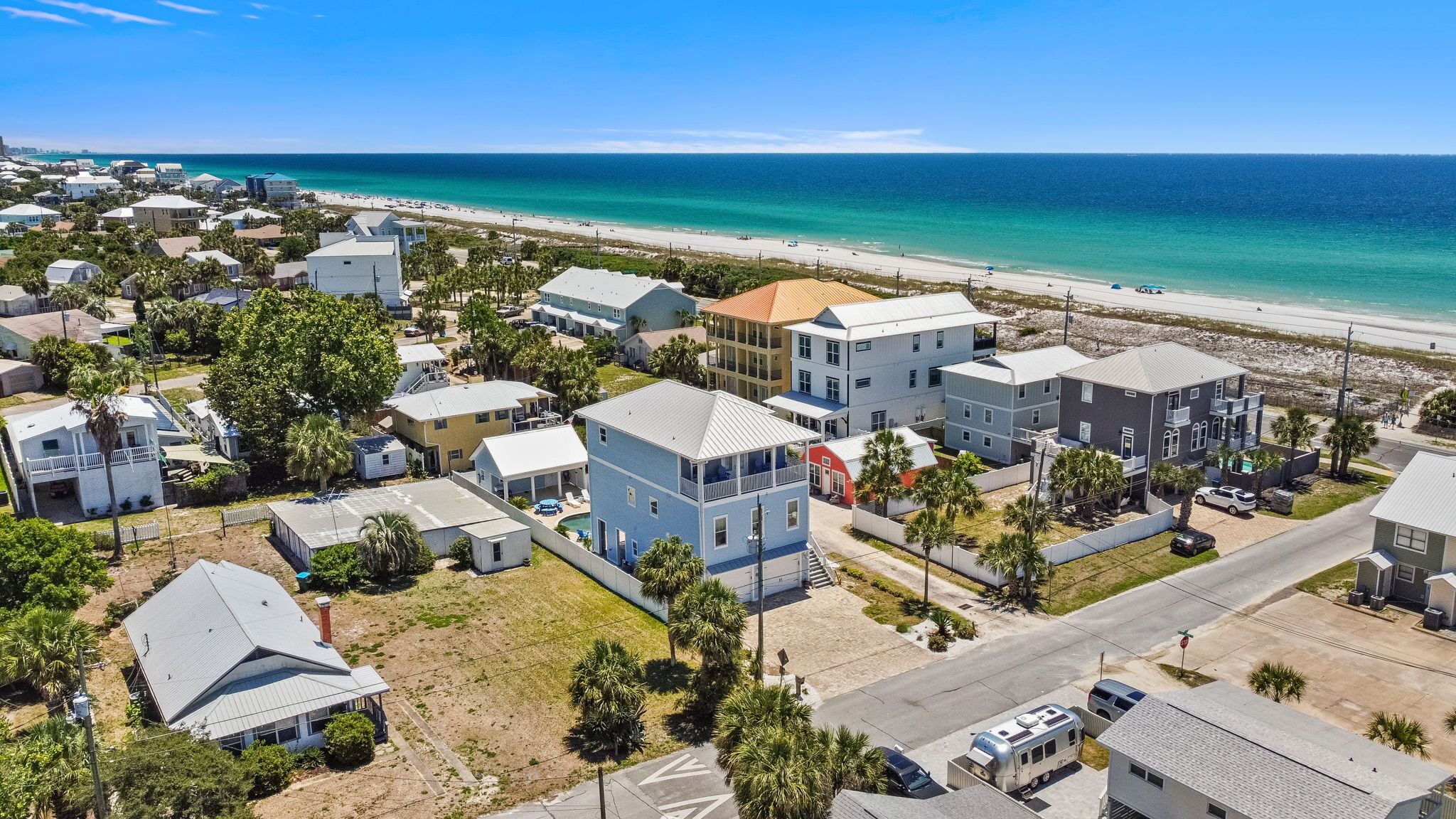 Una zona residencial costera con casas, una playa y una vista despejada del océano.