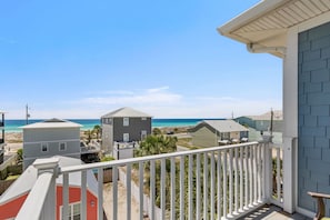Eine Wohngegend an der Küste mit Häusern, einem Balkon und freiem Blick auf den Strand.