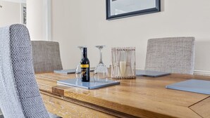 A dining table with a bottle of wine, two glasses, and a candle holder. - Spacious sea view apartment, West Hoe Free Parking (Plymouth)