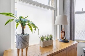 A wooden desk with a potted plant, a small terracotta pot with succulents, and a vintage-style desk lamp. - Lovely spacious, quiet ground floor apartment (Plymouth)