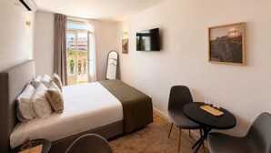 A hotel room with a bed, a TV, a desk with chairs, and a window with curtains. - Porto Ribeira Hotel - Superior Double Room (Porto)