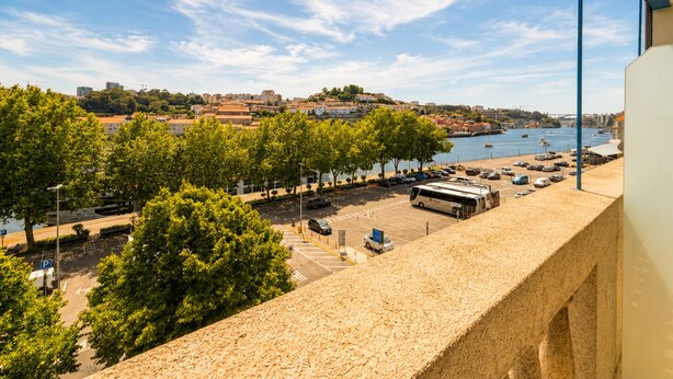 A coastal cityscape with a view of the sea, a parking area, and a building with a balcony overlooking the scene. - Porto Ribeira Hotel - Superior Double Room (Porto)