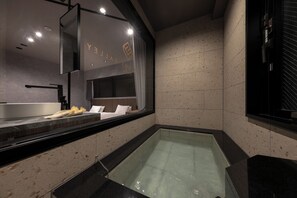 A modern bathroom with a large mirror, a bathtub, and a vanity with a sink. - THE SPRINGS VALLEY yufu (Yufu)