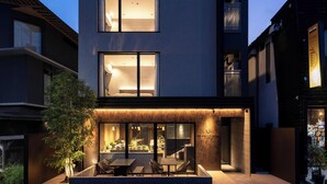 A modern building with a dining area, large windows, and a well-lit entrance.