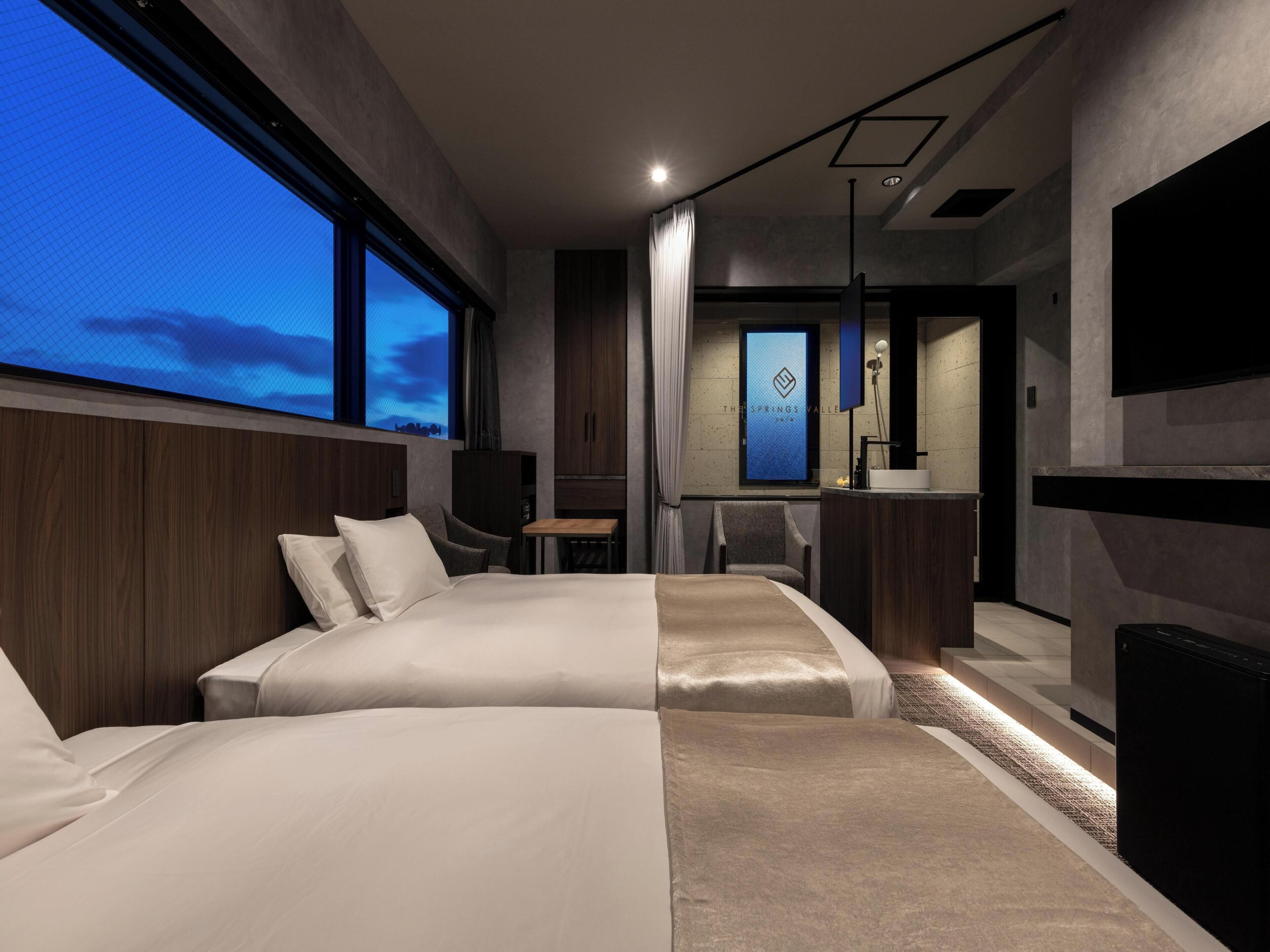 Una habitación de hotel moderna con una cama grande, un escritorio y un baño.