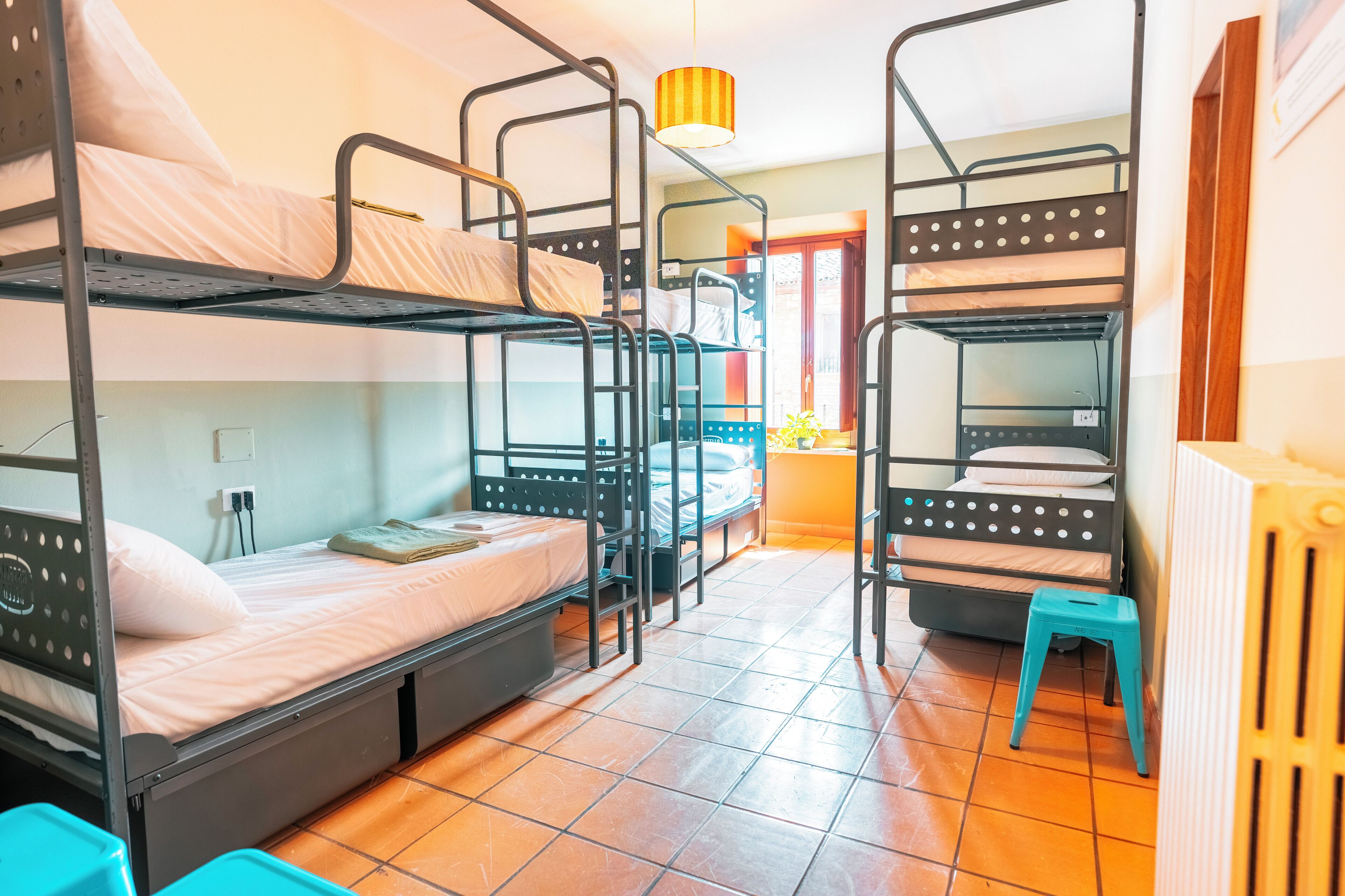 Un dormitorio con literas, un taburete pequeño y un radiador.