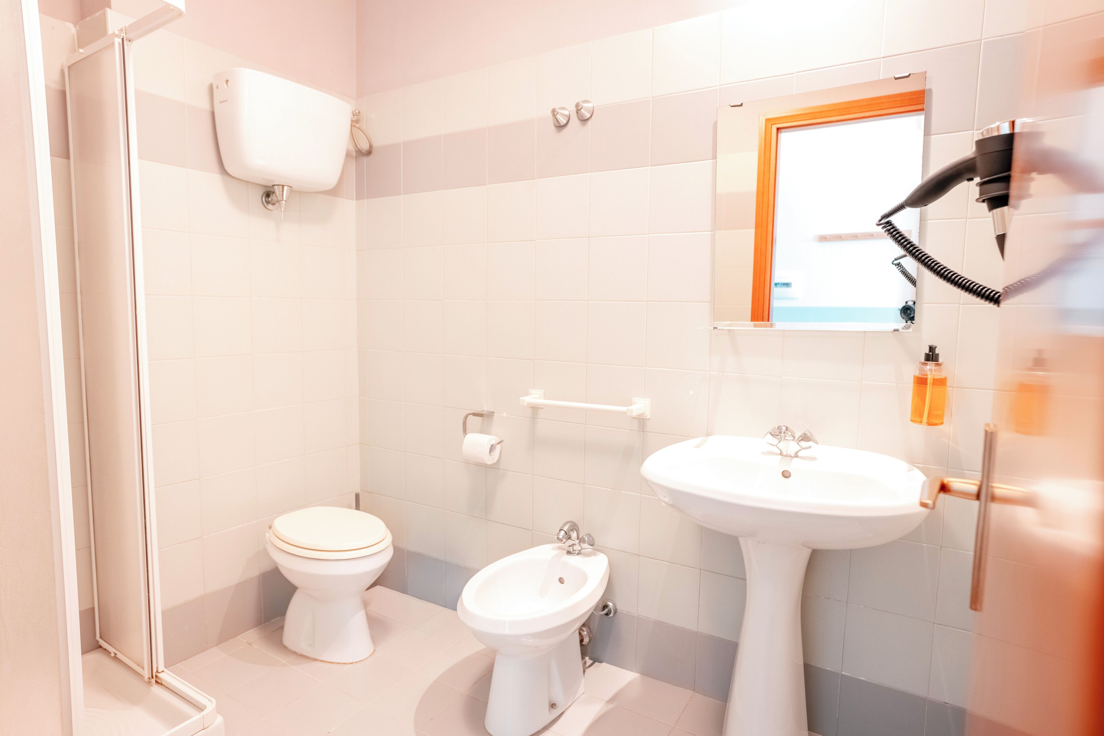A bathroom with a toilet, bidet, and sink.