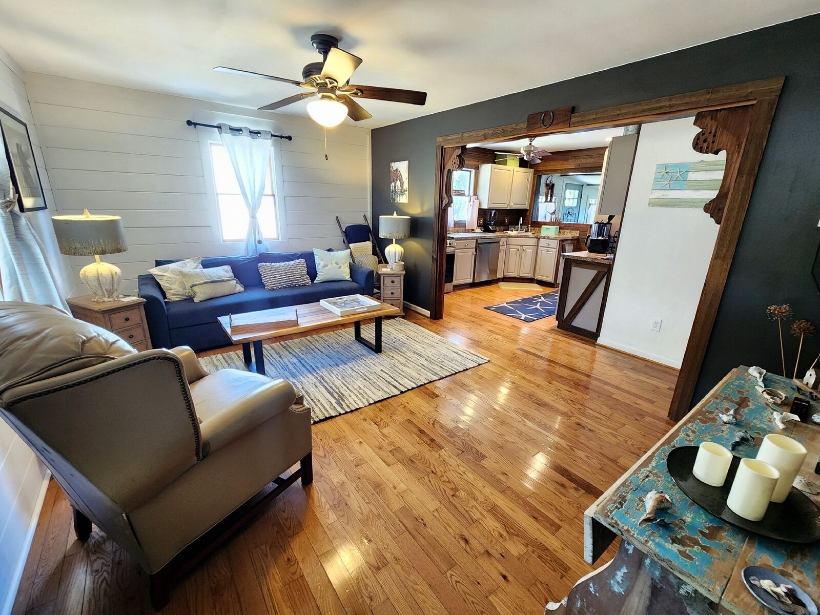 A living room with a sofa, coffee table, and a dining area with a table and chairs.