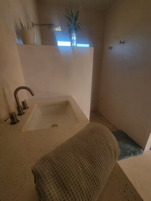 Ein Badezimmer mit Badewanne, Dusche, Handtuch und einer Topfpflanze.
