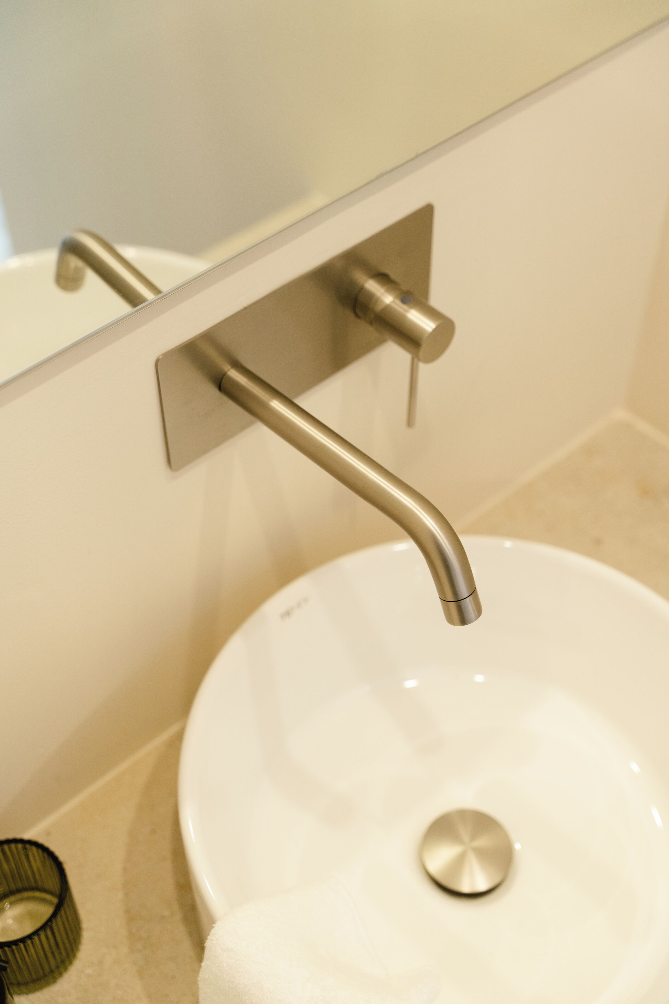 Un lavabo de salle de bain avec un robinet moderne et un miroir au-dessus.