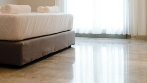 A hotel room with a bed, a wall-mounted air conditioner, and a large window with sheer curtains. - Yara (Nafpaktos)