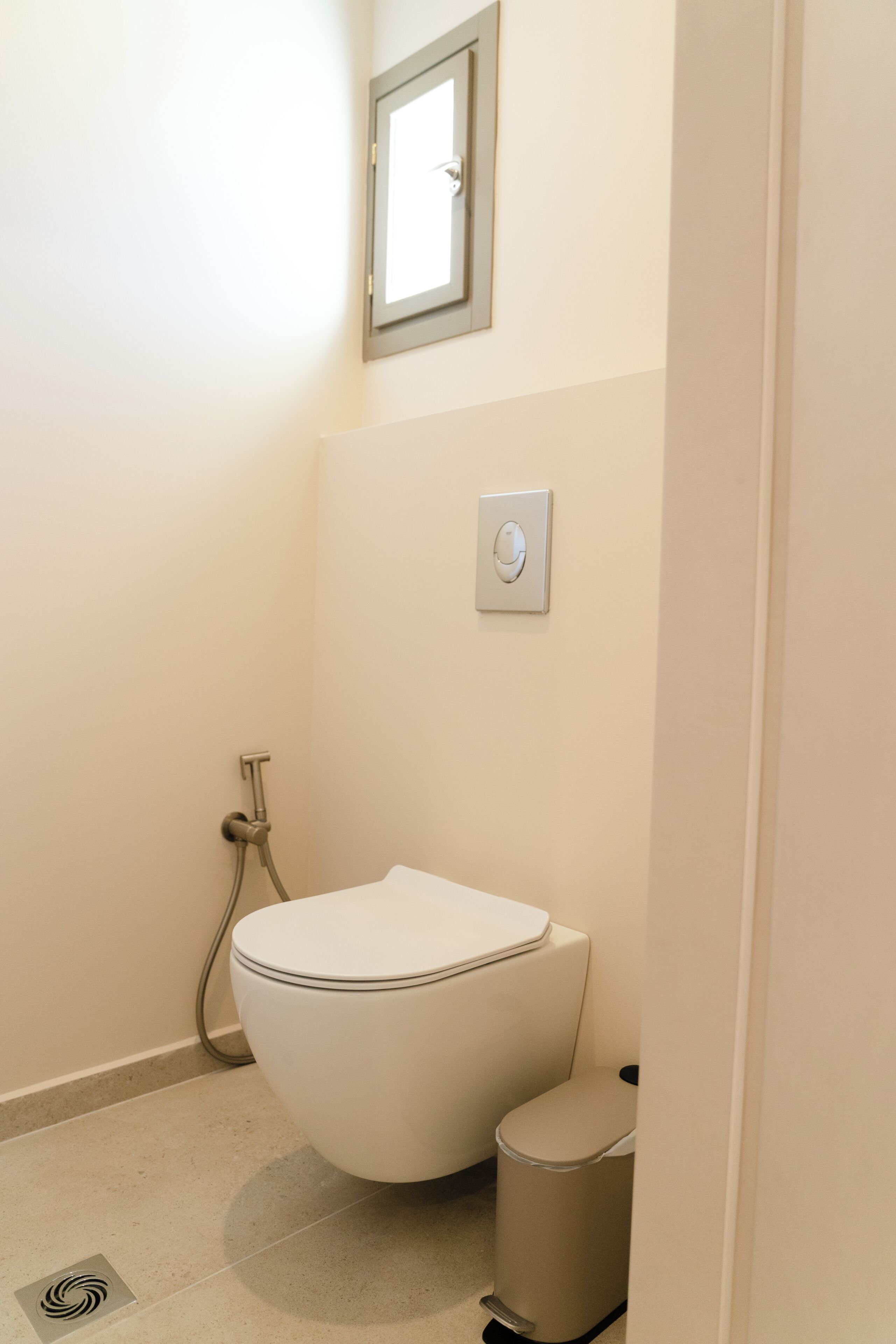 A bathroom with a toilet, a bidet, and a trash can.