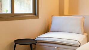 A small room with a window, a sofa, and a small table. - Yara (Nafpaktos)