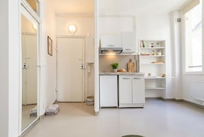 Eine kompakte Küche mit weißen Schränken, einem eingebauten Ofen und einer kleinen Arbeitsplatte.