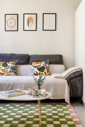 Ein modernes Wohnzimmer mit einer Couch, einem Couchtisch und einem gemusterten Teppich.