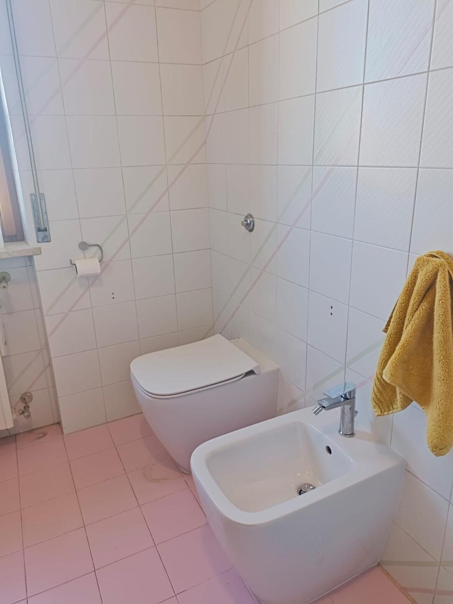 Une salle de bain équipée de toilettes, d’un bidet et d’un lavabo.