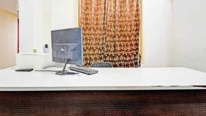 Un comptoir d’accueil équipé d’un écran d’ordinateur, d’un téléphone et d’une télécommande.