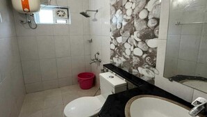 Une salle de bain équipée de toilettes, d’un lavabo, d’une douche et d’un sèche-mains.