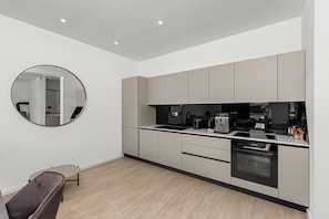 Eine moderne Küche mit rundem Spiegel, integrierten Geräten und schlichtem Design.