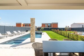 Ein Poolbereich auf dem Dach mit Liegestühlen, einem kleinen Pool und Blick auf Gebäude.