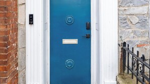 Une porte bleue, surmontée du numéro 165, intégrée à un bâtiment en pierre et en briques.