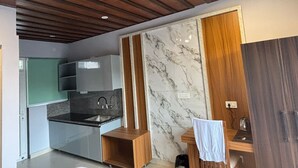 Eine moderne Küche mit Marmorfliesenspiegel, Holzboden und Einbauküchenschränken.