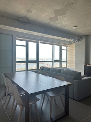 Una cocina moderna con comedor, ventanas amplias y vistas al mar.