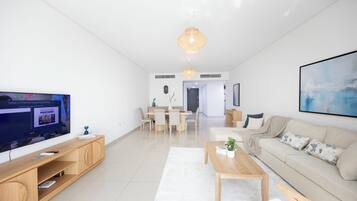 Un salon moderne avec un téléviseur, des meubles en bois, un canapé et un coin repas.