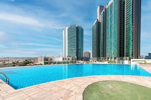 Una piscina con vista despejada a altos edificios al fondo.