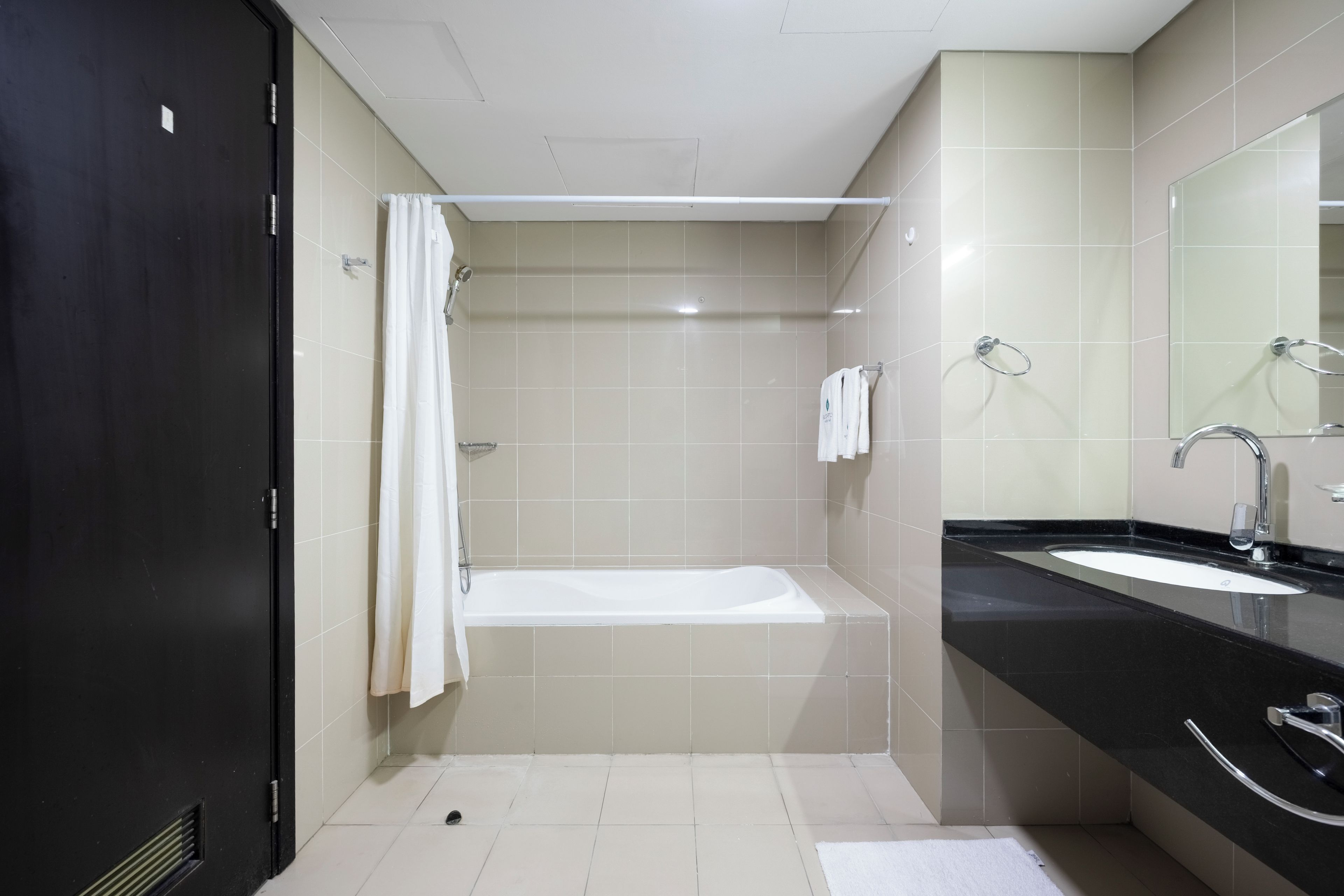 A modern bathroom with a bathtub, a sink, and a mirror.