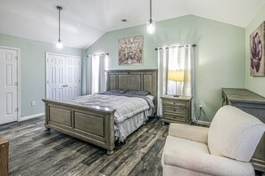 A bedroom with a bed, bedside tables, a chair, and a painting on the wall. - NJNY Retreat - Newark (Newark)