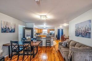 A modern apartment with a dining area, kitchen, and living room. - NJNY Retreat - Newark (Newark)