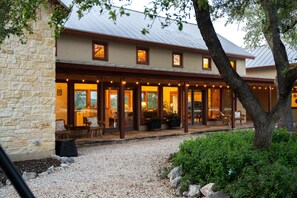 A two-story building with a stone facade, large windows, and outdoor seating area. - The Ranch House (Hondo)