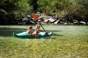 Dos personas en un kayak verde en un río.