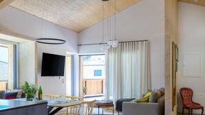 Et moderne interiør med spiseplads, sofa og tv.