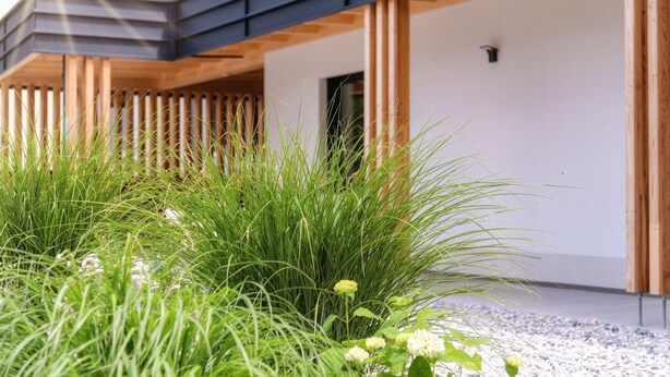 Un edificio moderno con una terrazza in legno e una parete bianca.
