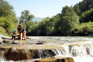 A natural setting with a river, rocks, and greenery.