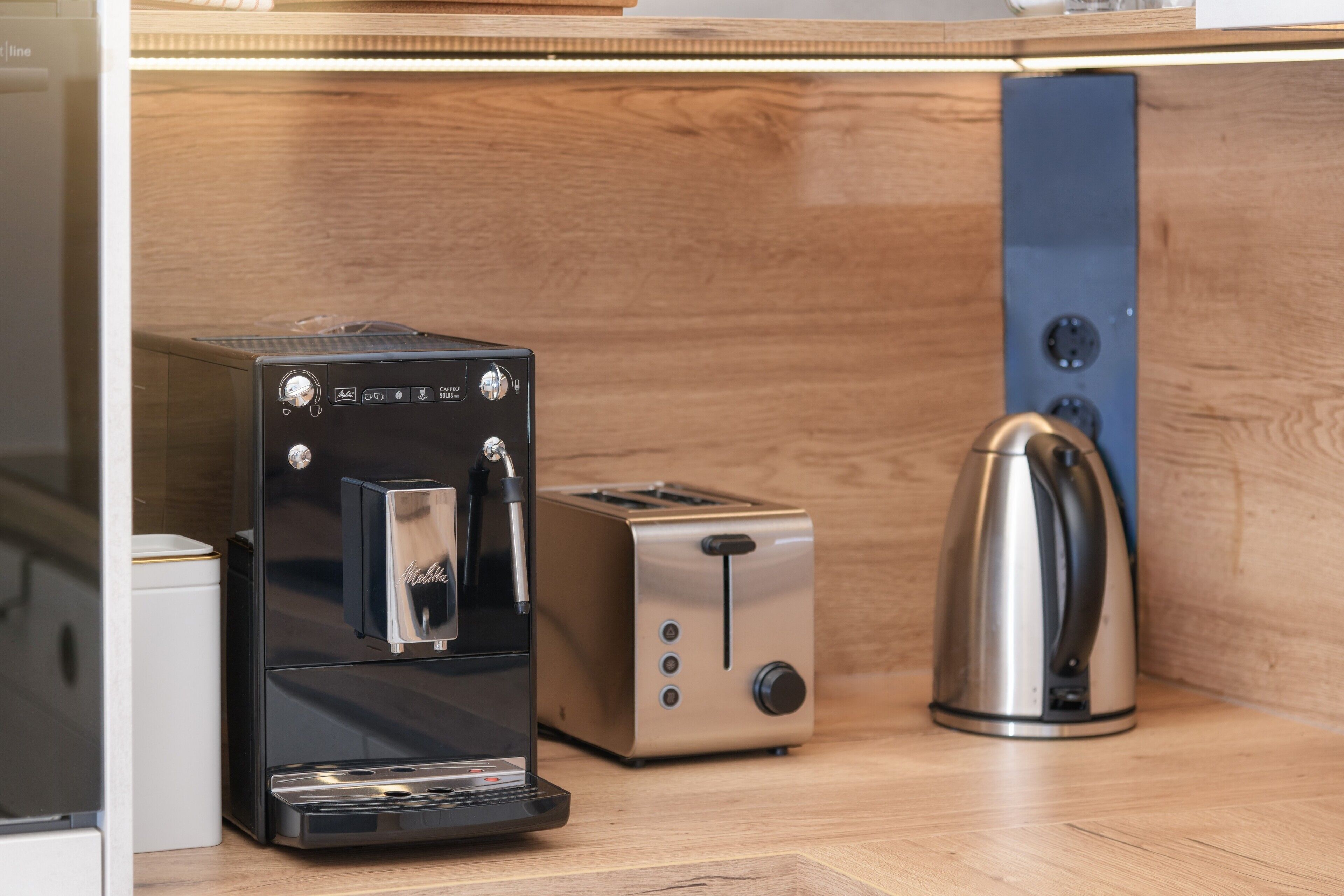 Eine Küchenzeile mit Kaffeemaschine, Toaster und Wasserkocher.
